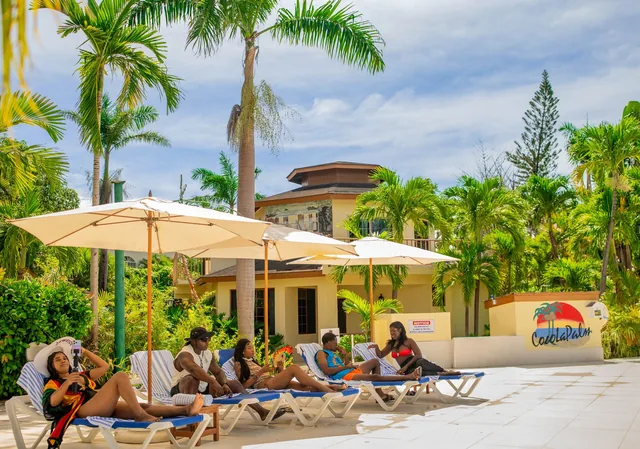 Guests relaxing on loungers beside CocoLaPalm's courtyard pool